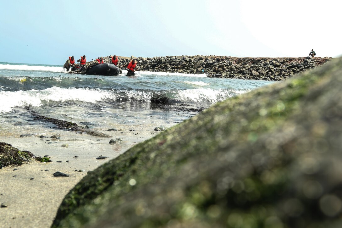 Belizean competitors pull a Zodiac craft from the Pacific Ocean during a water event May 6, as part of Fuerzas Comando 2016 in Ancon, Peru. Through friendly competition, Fuerzas Comando promotes military-to-military relationships, increases training knowledge, and improves regional security. (U.S. Army photo by Staff Sgt. Chad Menegay/Released)