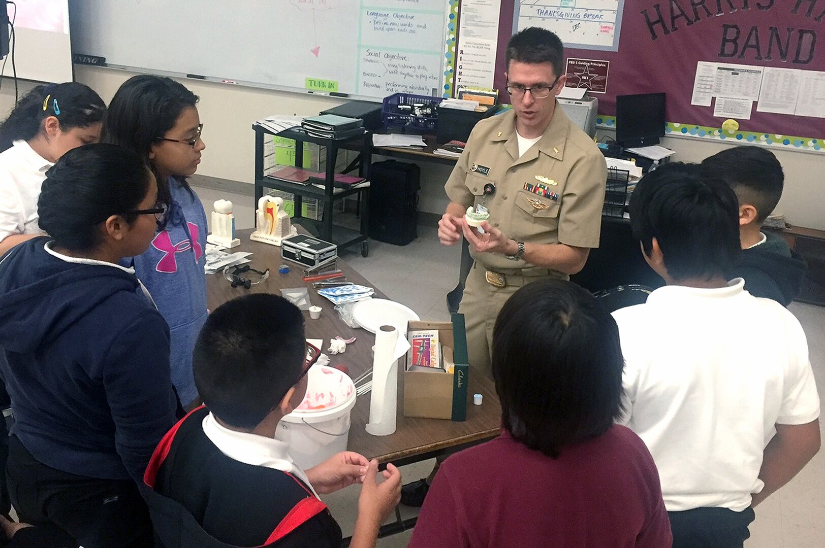 Lt. Cmdr. Jeffery Hoyle, a research dentist with the Naval Medical Research Unit San Antonio at Joint Base San Antonio-Fort Sam Houston, demonstrates the casting of a dental mold with silicone pressure material during his presentation at the Joel C. Harris Academy Middle School Career Day in San Antonio Nov. 16, 2016.