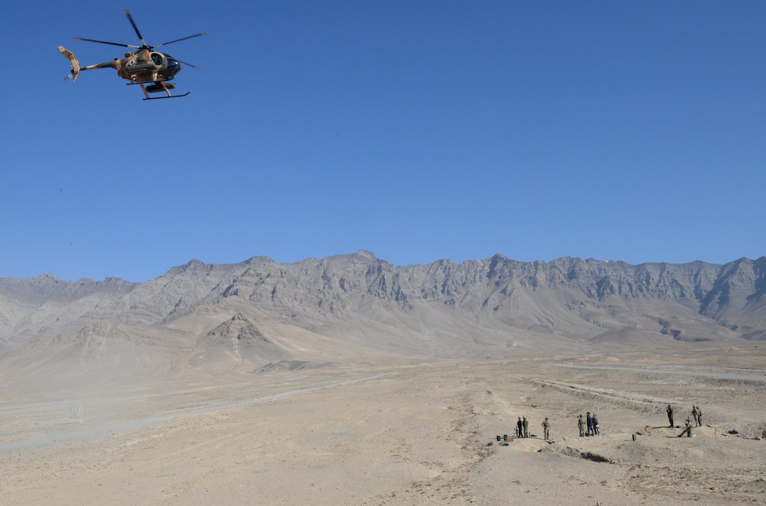 An Afghan Air Force MD-530 helicopter flies over Afghan National Defense and Security Forces members during an air-to-ground integration exercise in Kabul Province, Afghanistan, Dec. 27, 2016. The intergration of air-to-ground training usied aerial fires and close air support capabilities to further develop ANDSF operations. (NATO photo by Kay M. Nissen)
