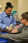 Raquel Hoskins, 5th Medical Support Squadron medical laboratory technician, draws blood from a patient at Minot Air Force Base, N.D., Dec. 13, 2016. Medical laboratory technicians draw blood samples to aid medical providers with diagnosing and following up with previous diagnoses.  (U.S. Air Force photo/Airman 1st Class Jessica Weissman)