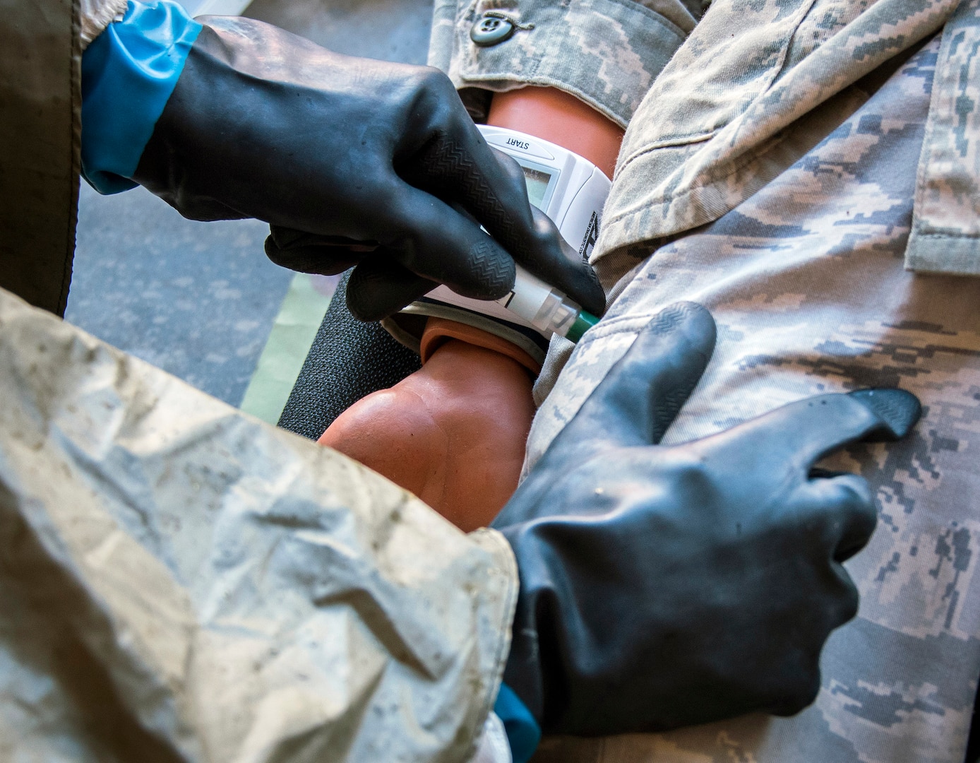 An airman uses an auto-injector on a medical mannequin during training.