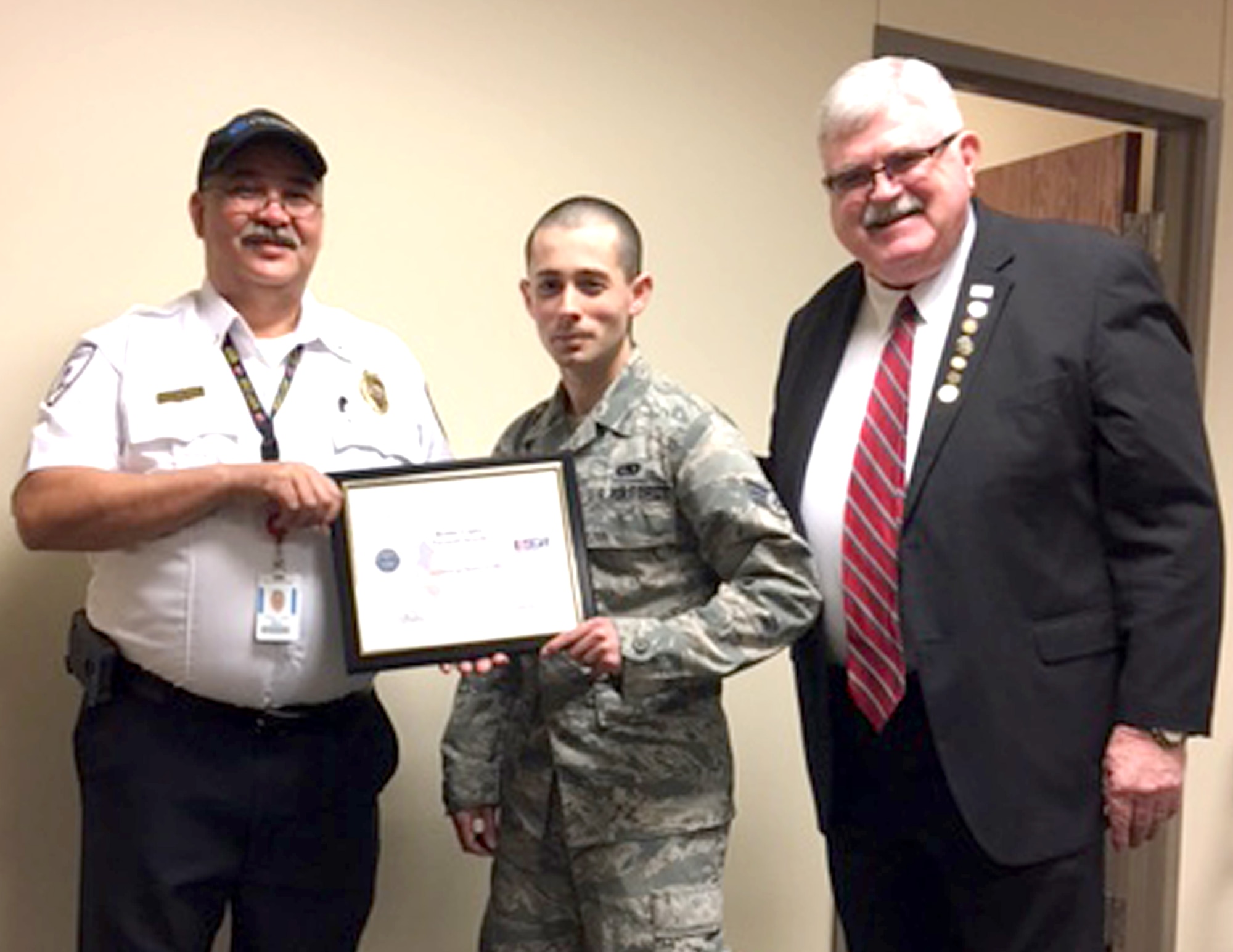 Senior Airman Taylor Mogford, 433rd Logistics Readiness Squadron supply journeyman, presents Benito Lopez, Covenant Security, with the Employer Support for the Guard and Reserve's Patriot Award for his support Jan. 2, 2017. Mr. Lopez approved Mogford's annual tour dates and filled in for him when he was called to participate in a  real-world military exercise.  (U.S. Air Force photo by Benjamin Faske)