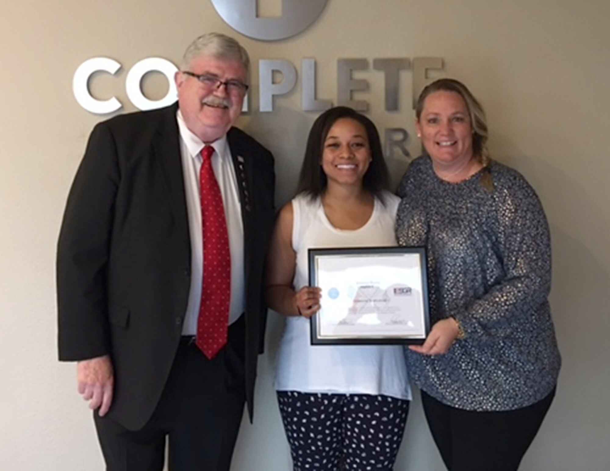 Jim Cunningham, Employer Support for the Guard and Reseve volunteer, presents Jeannie Berry, Complete Care supervisor, with the Patriot Award Dec. 27, 2016. Berry was nominated  by Capt. Jasmine Davis, 433rd Aeromedical Evacuation Squadron flight nurse, for supporting her during flight school and for an eight month active order assignment. (U.S. Air Force photo by Benjamin Faske)