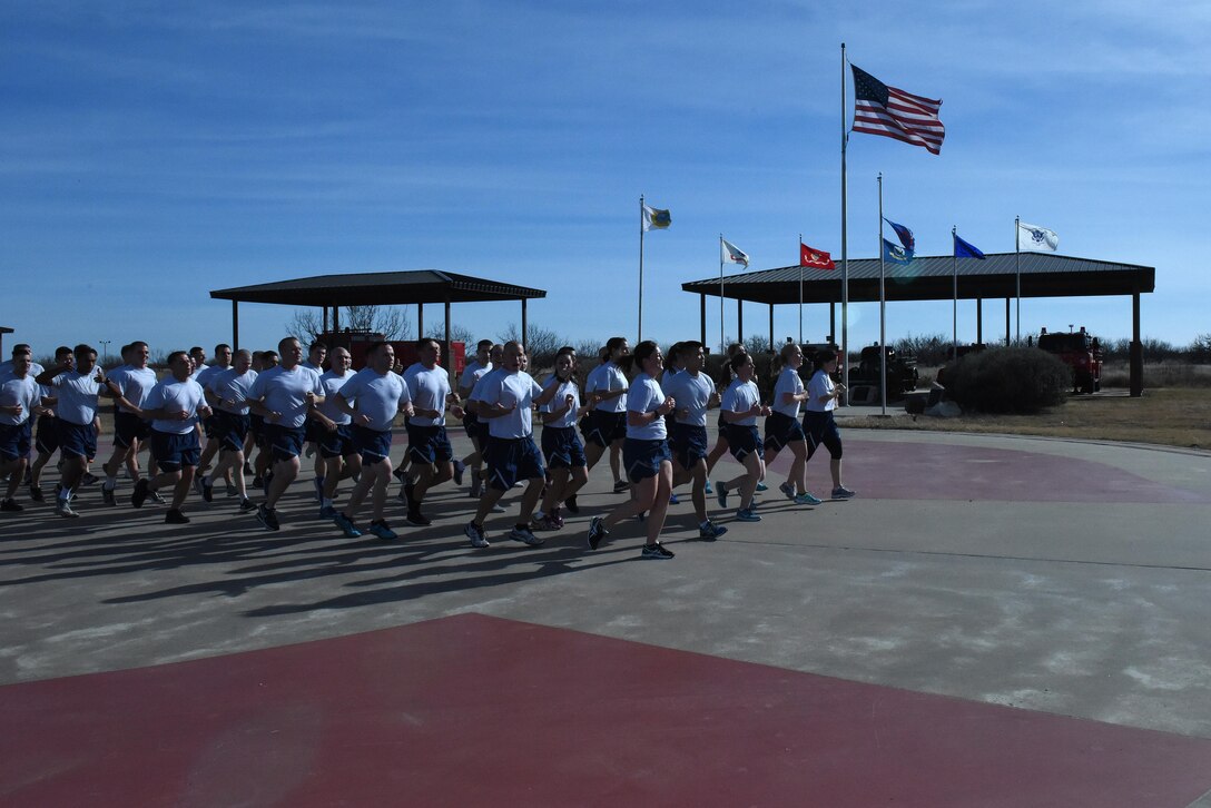 U.S. Air Force Airmen pass the Department of Defense Firefighter Memorial Park during the 17th Training Group formation run at Goodfellow Air Force Base, Texas, Jan. 3, 2017. The route was specifically designed to remind 17th TRG personnel of the base’s heritage. (U.S. Air Force photo by Airman 1st Class Caelynn Ferguson/ Released)