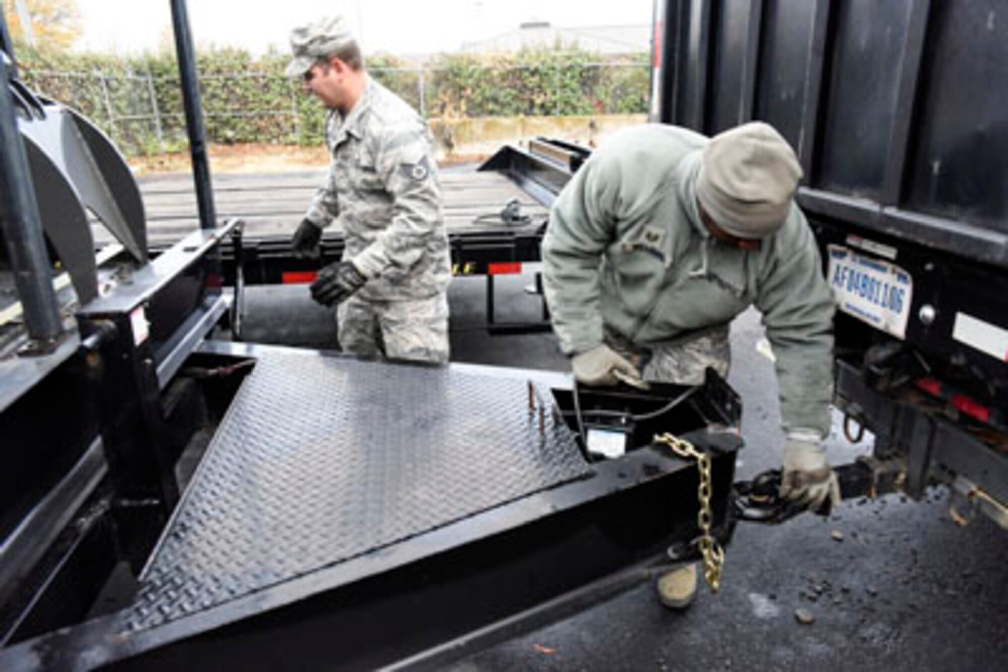 Staff Sgt. Bruce Booth, a 189th Logistics Readiness Squadron vehicle maintenance mechanic and Tech. Sgt. Patrick Williams, a 189th LRS cargo specialist, hook a trailer to a truck in order to pull a transportation platform out during a Rapid Augmentation Team equipment load drill Nov. 29, 2016, at Little Rock Air Force Base, Ark. The team loaded heavy equipment and small vehicles on to the platform to practice readiness in the event of a state emergency. (U.S. Air National Guard photo by Tech. Sgt. Jessica Condit)