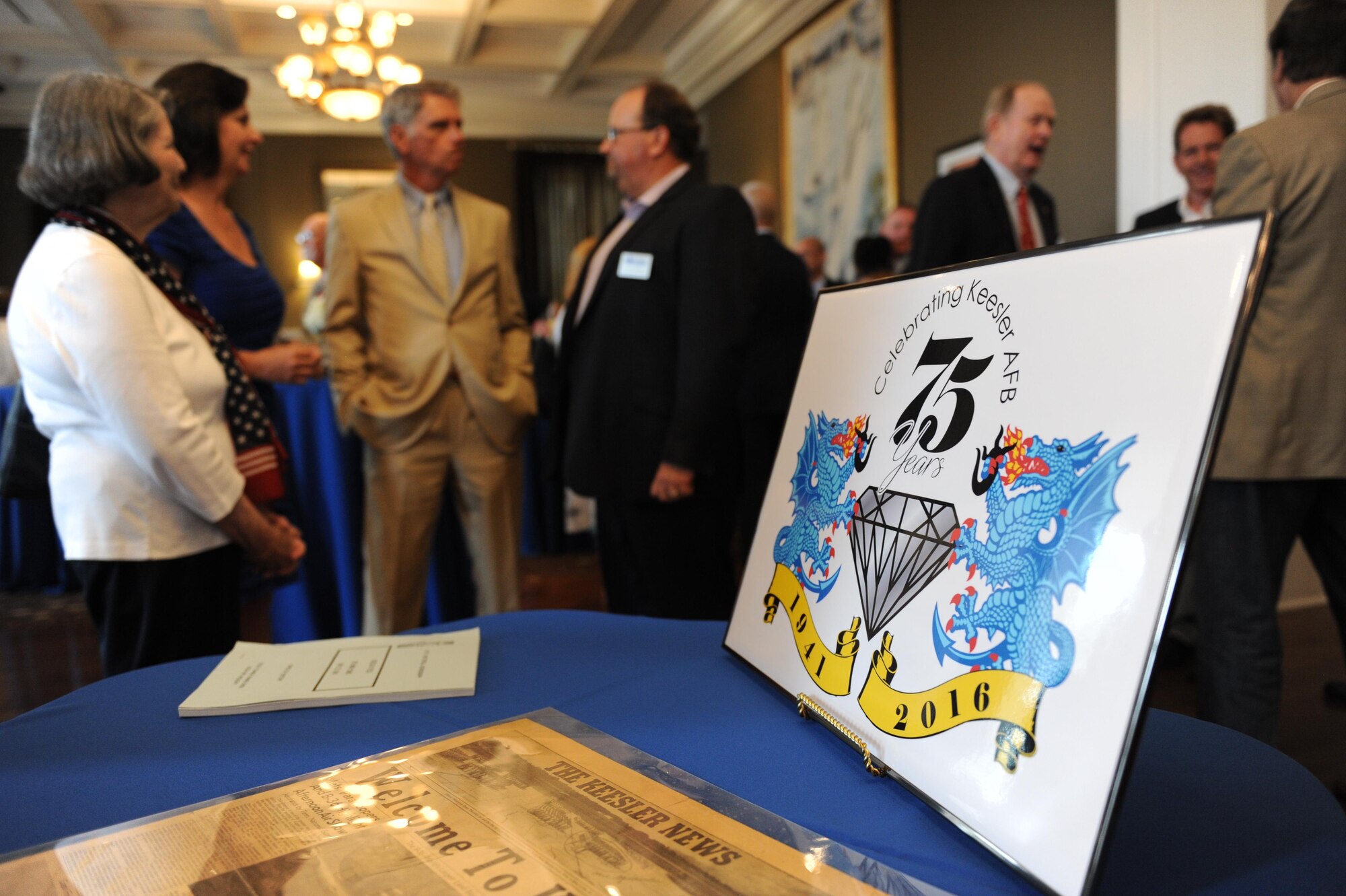 The 75th anniversary logo sits on a table at Keesler’s 75th Anniversary Historical Display Unveiling at the Biloxi Visitors Center June 3, 2016, Biloxi, Miss. A display featuring 14 historical panels created by Keesler personnel was unveiled along with the newest 75th anniversary logo. Additionally, Biloxi Mayor Andrew ‘FoFo’ Gilich read the “Biloxi/Keesler Partnership Day” proclamation at the event. (U.S. Air Force photo by Kemberly Groue)