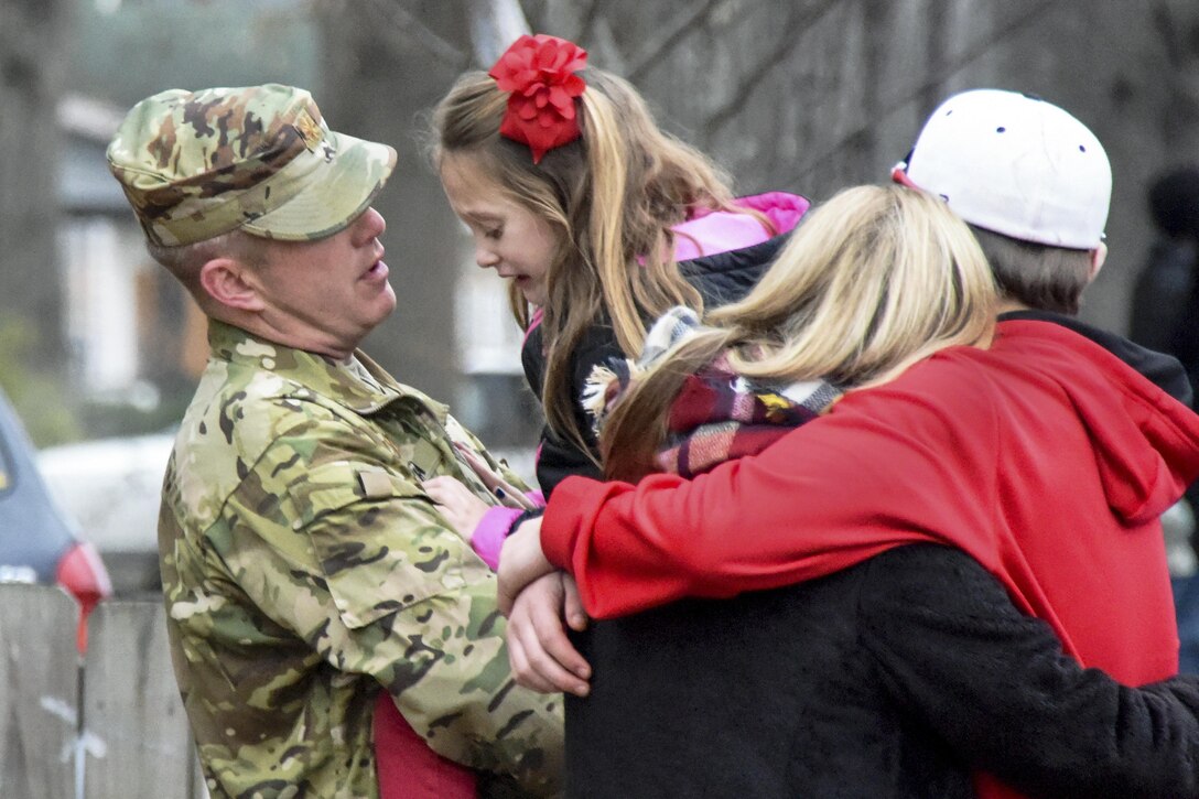 A soldier comforts his family after a deployment ceremony in Malvern, Ark., Jan. 1, 2017. The soldier, assigned to Headquarters Company, 1st Battalion, 153rd Infantry Regiment, 39th Infantry Brigade Combat Team, will serve in the Horn of Africa with about 700 members of his unit. Army photo by Sgt. Stephen Wright