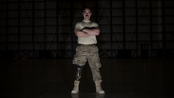 Tech. Sgt. Jason Caswell, 455th Expeditionary Aircraft Maintenance Squadron C-130 Hercules debrief NCO-in-charge, stands in a C-130 hangar at Bagram Airfield, Afghanistan, Jan. 5, 2017. After a sports injury in 2010, Caswell underwent a year of surgeries, two years of painful limb-recovery therapy, followed by physical therapy. In October 2014, his limb still hadn’t healed and began to worsen. Caswell elected to amputate his injured leg. (U.S. Air Force photo by Staff Sgt. Katherine Spessa)