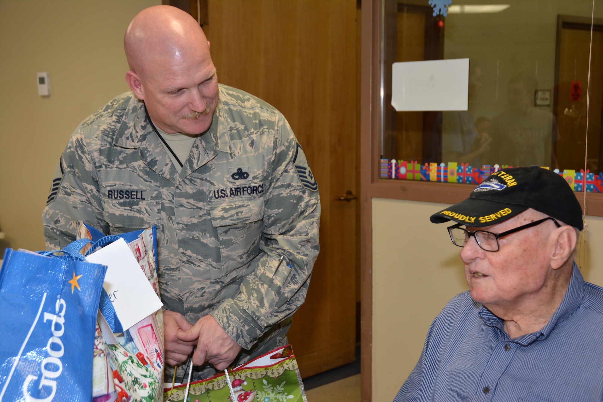 Master Sgt. Jon Russell of the 507th Maintenance Squadron delivers a gift bag and listens to Norman Veterans Center resident talk about his time in the U.S. Army Dec. 22, 2016 in Norman, Okla. (U.S. Air Force photo/Maj. Jon Quinlan)   
