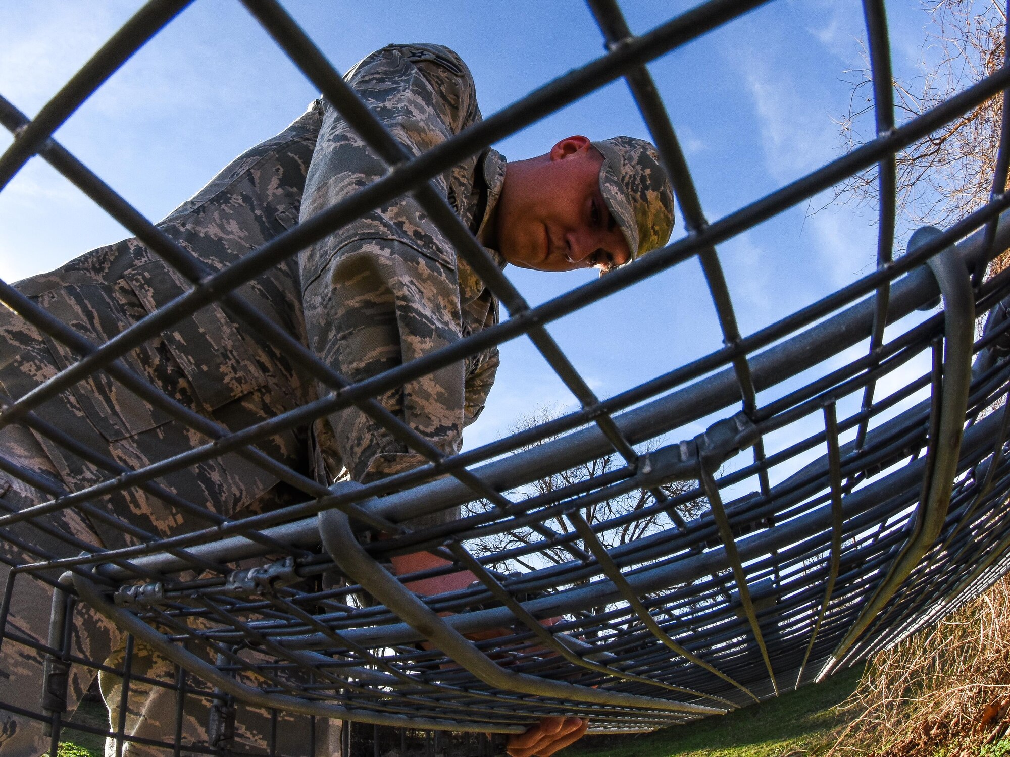Airman 1st Class Christopher Cooper, 2nd Civil Engineer Squadron pest management journeyman, installs a trap for wild dogs that were loose at Barksdale Air Force Base, La., Jan. 3, 2017. Wild dogs can not only be aggressive, but can also carry disease which can be transferred to house pets and people on base. (U.S. Air force photo/Senior Airman Luke Hill)