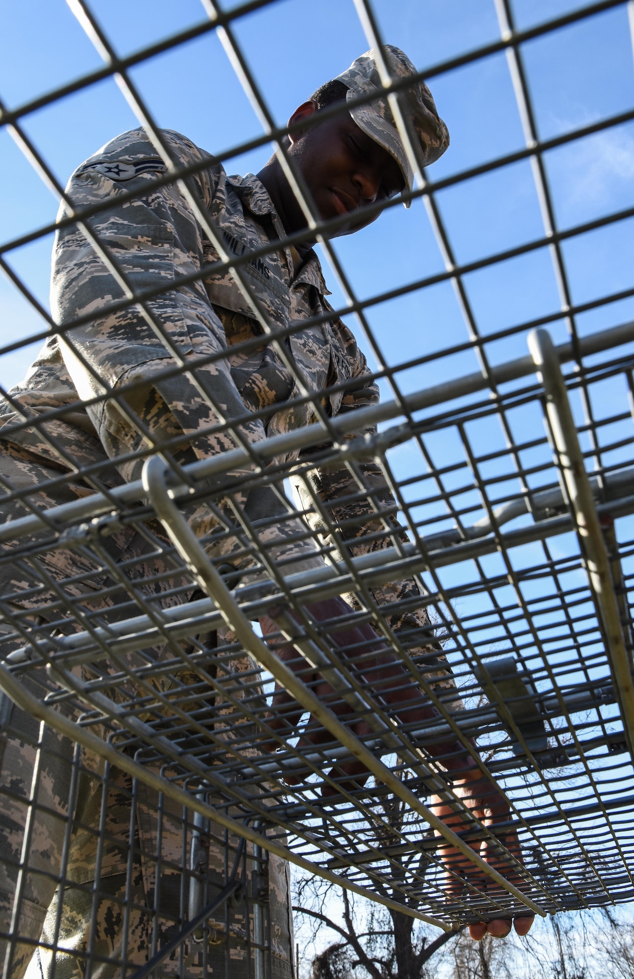 Airman 1st Class Keanan Williams, 2nd Civil Engineer Squadron pest management journeyman, installs a trap for wild dogs that were loose at Barksdale Air Force Base, La., Jan. 3, 2017. Wild dogs can not only be aggressive, but can also carry disease which can be transferred to house pets and people on base. (U.S. Air force photo/Senior Airman Luke Hill)