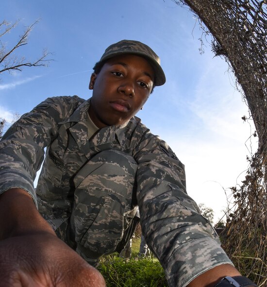Airman 1st Class Amber McDaniel, 2nd Civil Engineer Squadron pest management journeyman, installs a trap near an entry point that wild dogs have been using to access Barksdale Air Force Base, La., Jan. 3, 2017. Once caught, the wild dogs are removed from base quickly and safely. (U.S. Air force photo/Senior Airman Luke Hill)