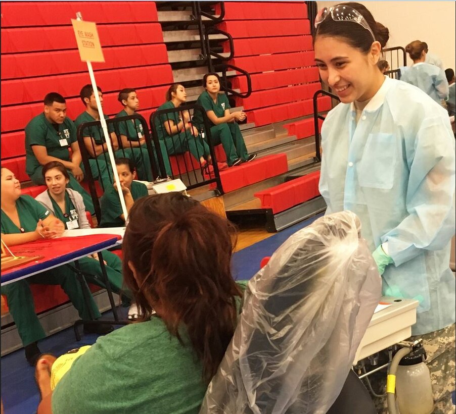 Army Reserve Sgt. Yajaira Villareal, a dental technician with the 804th Medical Brigade, speaks with a patient during Operation Lone Star at Juarez-Lincoln High School in LaJoya, Texas, July 25, 2016. This year the Army Reserve will partner with Texas A&M to provide dental and medical care at four colonias near Laredo, Texas, June 17 to July 1. (Photo Credit: Pfc. Aminata Keita)