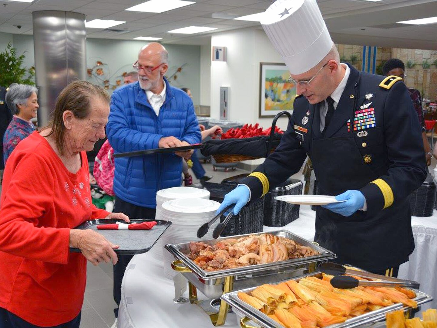 Brig. Gen. Jeffrey Johnson (right), Brooke Army Medical Center commanding general, helps serve Christmas dinner to patients and staff in the BAMC dining room at Joint Base San Antonio-Fort Sam Houston Dec. 25, 2016. 