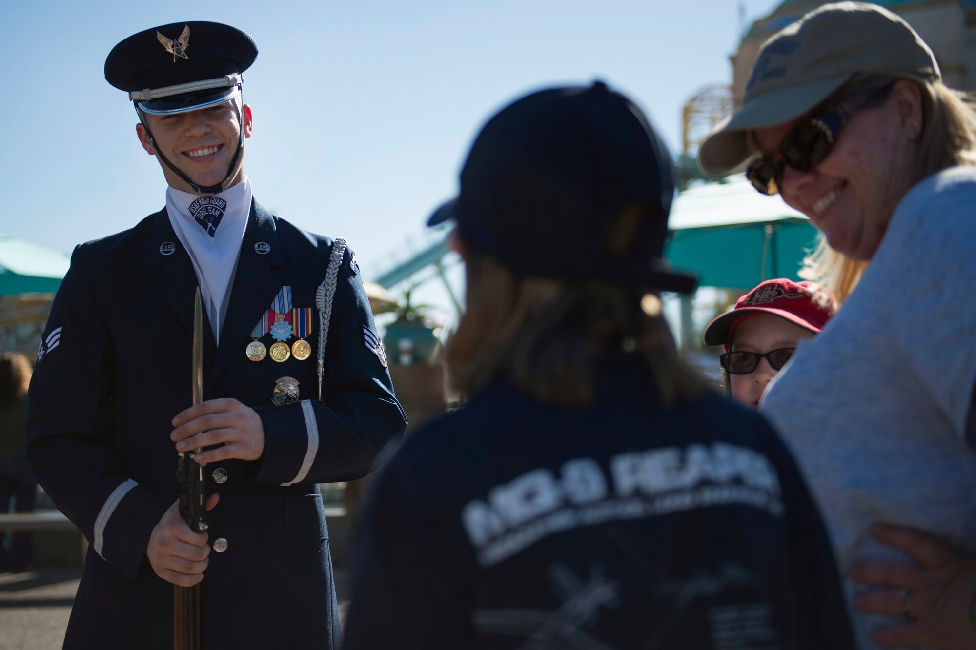 Senior Airman Jacob Wilson, U.S. Air Force Honor Guard Drill Team member, speaks with a young girl about the Air Force after a performance at Sea World in San Diego, Calif., Dec. 29, 2016. The drill team showcases their drill performances at public venues, such as Sea World, to recruit and inspire the public. (U.S. Air Force photo by Senior Airman Philip Bryant)