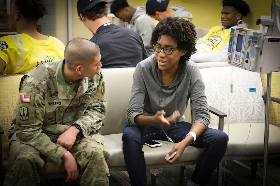 Army Staff Sgt. Jonathan Crespo, a recruiter assigned to the U.S. Army Recruiting Command and Soldier mentor for high-school athletes in the U.S. Army All-American Bowl, visits with Brian McGraw, one of the children in the Children's Health Department of the University Hospital in San Antonio.  More than 30 high-school athletes from the All-American Bowl teams along with their Soldier mentors took the opportunity to visit with kids at the hospital as part of a community relations event Jan. 3.  The group is in San Antonio preparing for the U.S. Army All-American Bowl scheduled for Jan. 7.  The bowl has been the nation's premier high school football game for 16-years, serving as the preeminent launching pad for America's future college and National Football League stars. (Official U.S. Army Reserve Photo by Sgt. 1st Class Brent C. Powell)