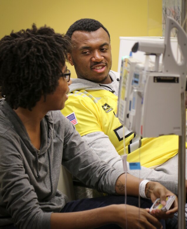 Austin Jackson, left guard and tight end from Phoenix, Arizona, who will represent the west team in the upcoming U.S. Army All-American Bowl on Jan. 7, talks to Brian McGraw, one of the children in the Children's Health Department of the University Hospital in San Antonio.  More than 30 athletes and their Soldier mentors took the opportunity to visit with kids at the hospital as part of a community relations event Jan. 3.  For 16 years the Army All-American Bowl has been the nation's premier high school football game, serving as the preeminent launching pad for America's future college and National Football League stars. (Official U.S. Army Reserve Photo by Sgt. 1st Class Brent C. Powell)