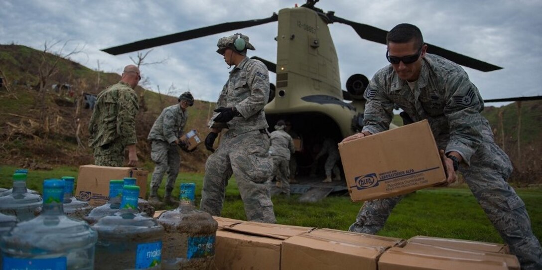 U.S. service members stack boxes of aid  which and water while off loading a U.S. Army CH-47 Chinook during an aid relief mission Oct. 14, 2016 in Anse d'Hainault, Haiti. Haiti was devastated by hurricane Matthew which killed more than 800 people. Joint Task Force Matthew is a comprised of multinational partners who are working together to provide and bring aid to those in need in Haiti.  (U.S. Air Force photo by Staff Sgt. Paul Labbe)