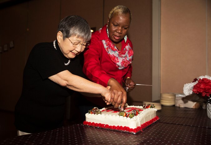 Hitomi Yamaguchi, a logistics-contractor specialist, left, Linda Brown, logistics contractor director, supervisor and friend to Yamaguchi, cut a retirement cake at Marine Air Station Iwakuni, Japan, Dec. 16, 2016. Yamaguchi celebrated her retirement after 42 years of service. She held four jobs in that time. She was a stock control clerk, voucher examiner, and an administrator specialist. However, she spent most of her time as a logistics-contractor specialist.  (U.S. Marine Corps photo by Lance Cpl. Gabriela Garcia-Herrera)