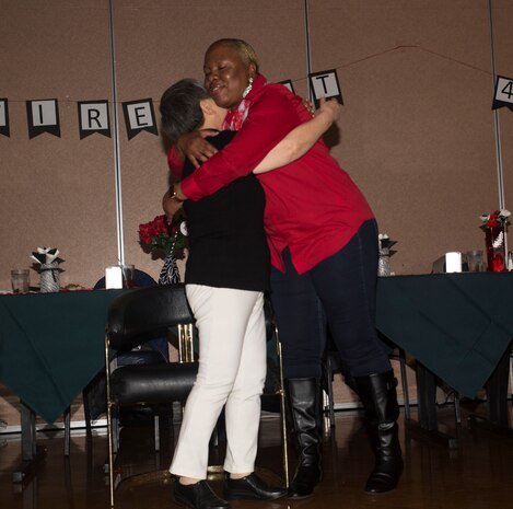 Hitomi Yamaguchi, a logistics-contractor specialist, hugs Linda Brown, logistics-contractor director, supervisor and friend to Yamaguchi, at her retirement ceremony at Marine Corps Air Station Iwakuni, Japan, Dec. 16, 2016.  Yamaguchi influenced a lot of people during her time on base, many of which attended the ceremony to help honor her loyal service and reminisce on the past 42 years. (U.S. Marine photo by Lance Cpl. Gabriela Garcia-Herrera)