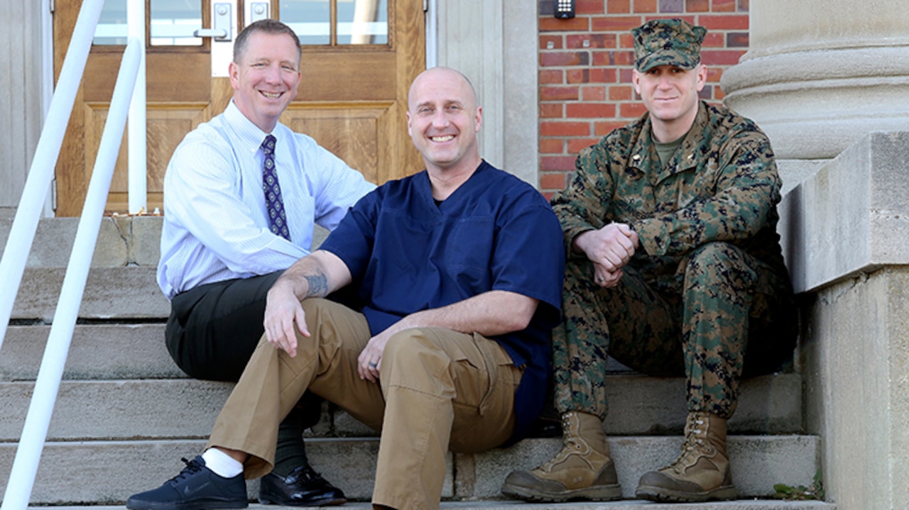 Joseph Klocek (left) and Maj. Scott Graniero (right) pose with Master Sgt. Clifford Farmer at Marine Corps Systems Command aboard Marine Corps Base Quantico, Va. Farmer credits the support and compassion of the two men—part of his leadership team at MCSC—with saving his life during a time when he contemplated suicide. Today, Farmer battles post-traumatic stress disorder and depression, and urges leaders across the Marine Corps to show understanding and compassion for Marines who may be suffering. (U.S. Marine Corps photo by Monique Randolph)