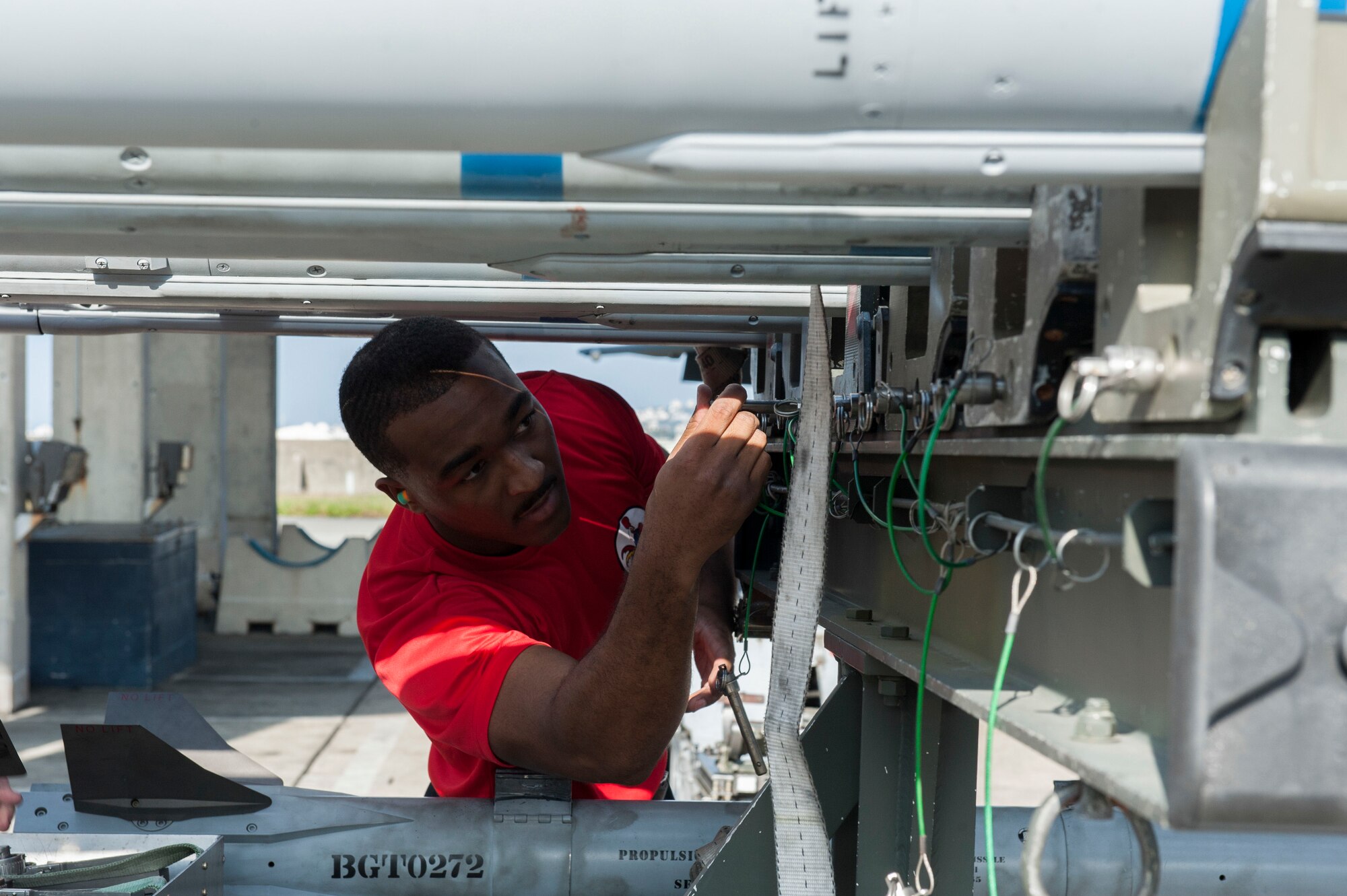 U.S. Air Force Senior Airman Andre Douglas prepares to load an AIM-120 Advanced Medium Range Air-to-Air Missile onto an F-15 Eagle Jan. 4, 2017, at Kadena Air Base, Japan. Weapons load crew members train monthly to maintain their loading qualifications and competency. (U.S. Air Force photo by Senior Airman Lynette M. Rolen/Released)