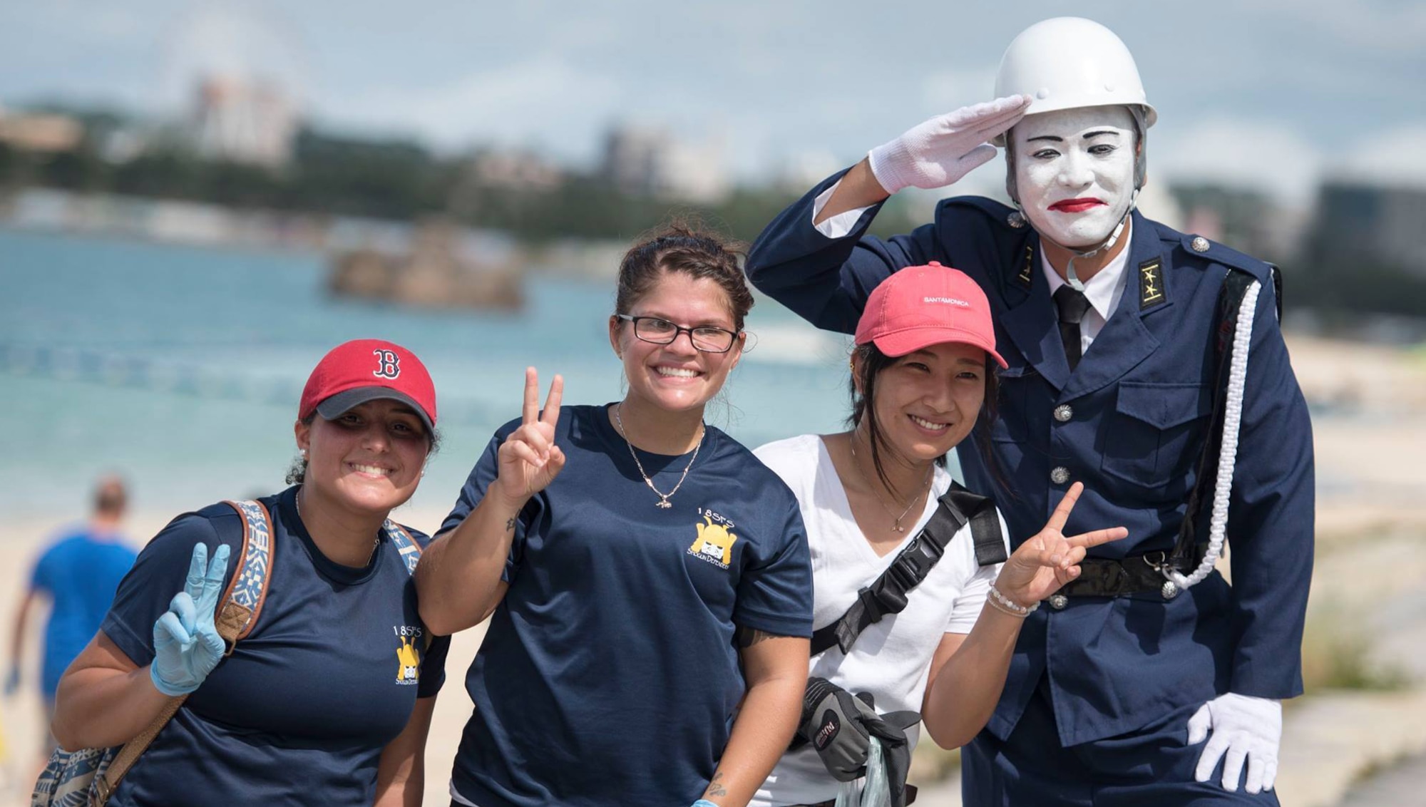 A cosplayed Mamoru-Kun renders a salute alongside members of Kadena Air Base and a local volunteer during a beach cleanup Oct. 9, 2016, at Araha Beach, Okinawa, Japan. Mamoru-Kun is an iconic figure from one of Okinawa’s smaller islands, Miyako-Jima, who stands post as a lookout for society. (U.S. Air Force photo by Senior Airman Omari Bernard)