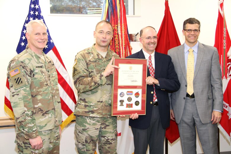Col. Christopher Barron  and Scott Acone stand with Brig. Gen. William Graham as he presents Jay Clement with a North Atlantic Division Certificate of Achievement.
