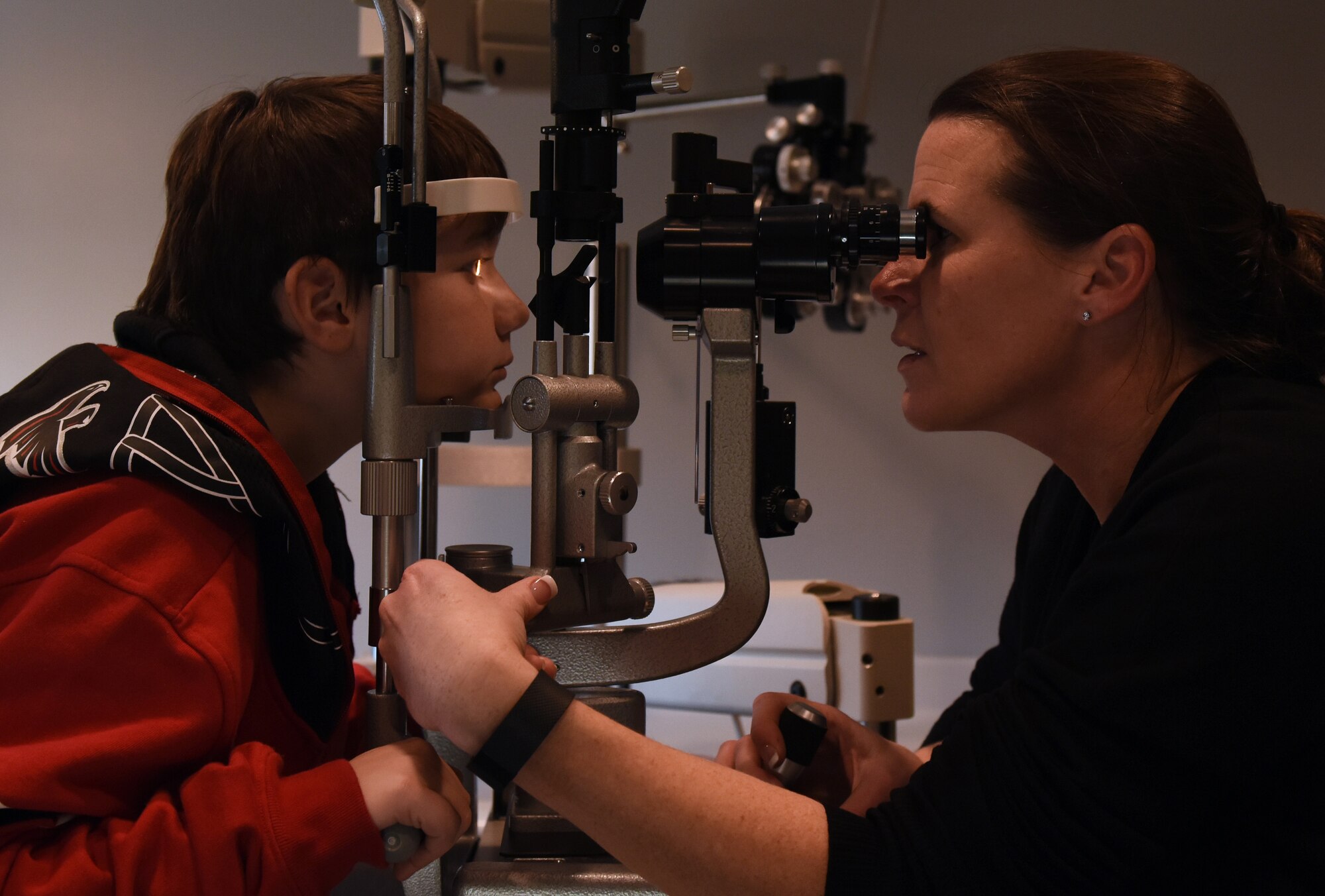 Patricia Hoogenveen, right, 19th Aerospace Medicine Squadron optometrist, examines Ian Clouse’s eyes during a routine eye exam Dec. 19, 2016, at Little Rock Air Force Base, Ark. The optometry clinic has extended their services to retirees and dependents starting January 2017. (U.S. Air Force photo by Senior Airman Mercedes Taylor)
