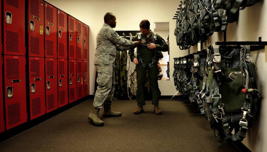 Maj. Matt Hellier (left), 1st Reconnaissance Squadron student pilot receives a parachute fitting from Staff Sgt. Matthew Young, 9th Operational Support Squadron noncommissioned officer in charge of aircrew flight equipment Jan. 5, 2016, at Beale Air Force Base, California. Aircrew flight equipment is responsible for all of a pilot’s gear such as helmet, oxygen mask, harness and all life-saving devices. (U.S. Air Force photo/Staff Sgt. Jeffrey Schultze)