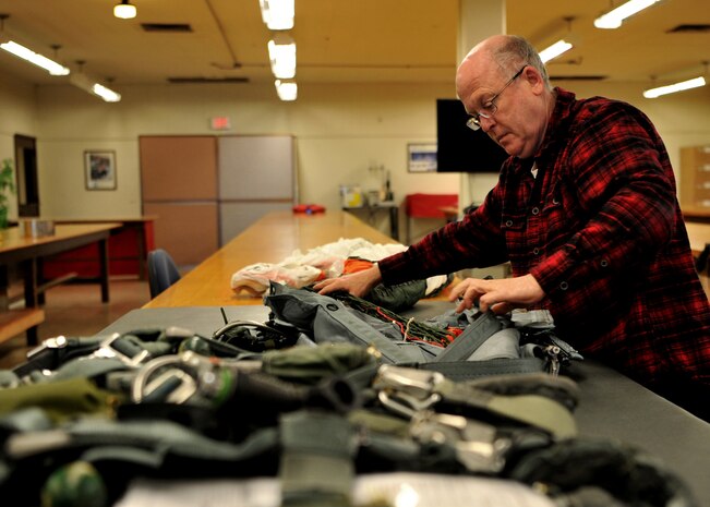 Ray Conner, 9th Operational Support Squadron aircrew flight equipment craftsman unpacks a parachute Jan. 5, 2016, at Beale Air Force Base, California. Aircrew flight equipment is responsible for all of a pilot’s gear such as helmet, oxygen mask, harness and all life-saving devices. (U.S. Air Force photo/Staff Sgt. Jeffrey Schultze)