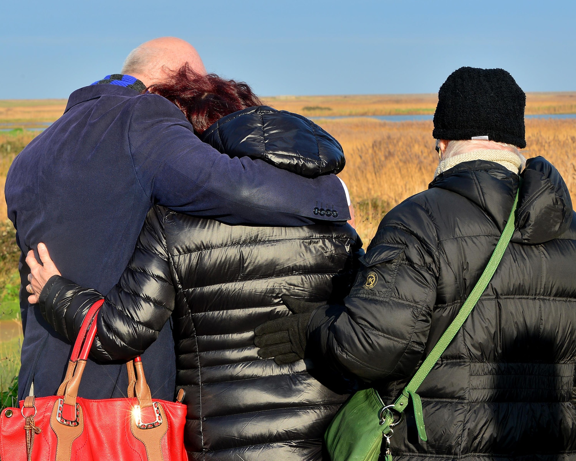 Local community members comfort Marcia Ruane, mother of Capt. Sean Ruane, as she views the memorial stone dedicated to her son and three other aircrew Jan. 6, 2017. Capt. Sean Raune, Capt. Christopher Stover, Tech. Sgt Dale Mathews and Staff Sgt Afton Ponce were killed when an HH-60G Pave Hawk helicopter crashed on the Norfolk coast Jan. 7, 2014. (U.S. Air Force photo/Staff Sgt. Stephanie Longoria)