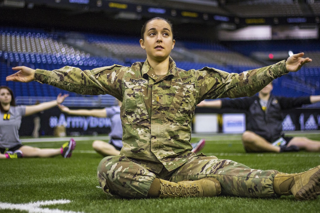 Army 2nd Lt. Sarah Herrero leads a stretch with the 2017 U.S. Army All-American Marching Band color guard in San Antonio, Jan. 4, 2017. Herrero, assigned to the 329th Movement Control Team, 330th Transportation Battalion, is an alumni of the 2009 color guard and returns each year as a soldier mentor during the Army All-American Bowl. Army photo by Cpl. Timothy Yao