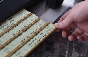U.S. Air Force Senior Airman Patrick Taylor, 1st Operations Support Squadron air traffic controller, organizes flight strips at Joint Base Langley-Eustis, Va., Dec. 16, 2016. Each strip has flight information including aircraft names, destinations and clearances. (U.S. Air Force photo by Staff Sgt. Natasha Stannard)