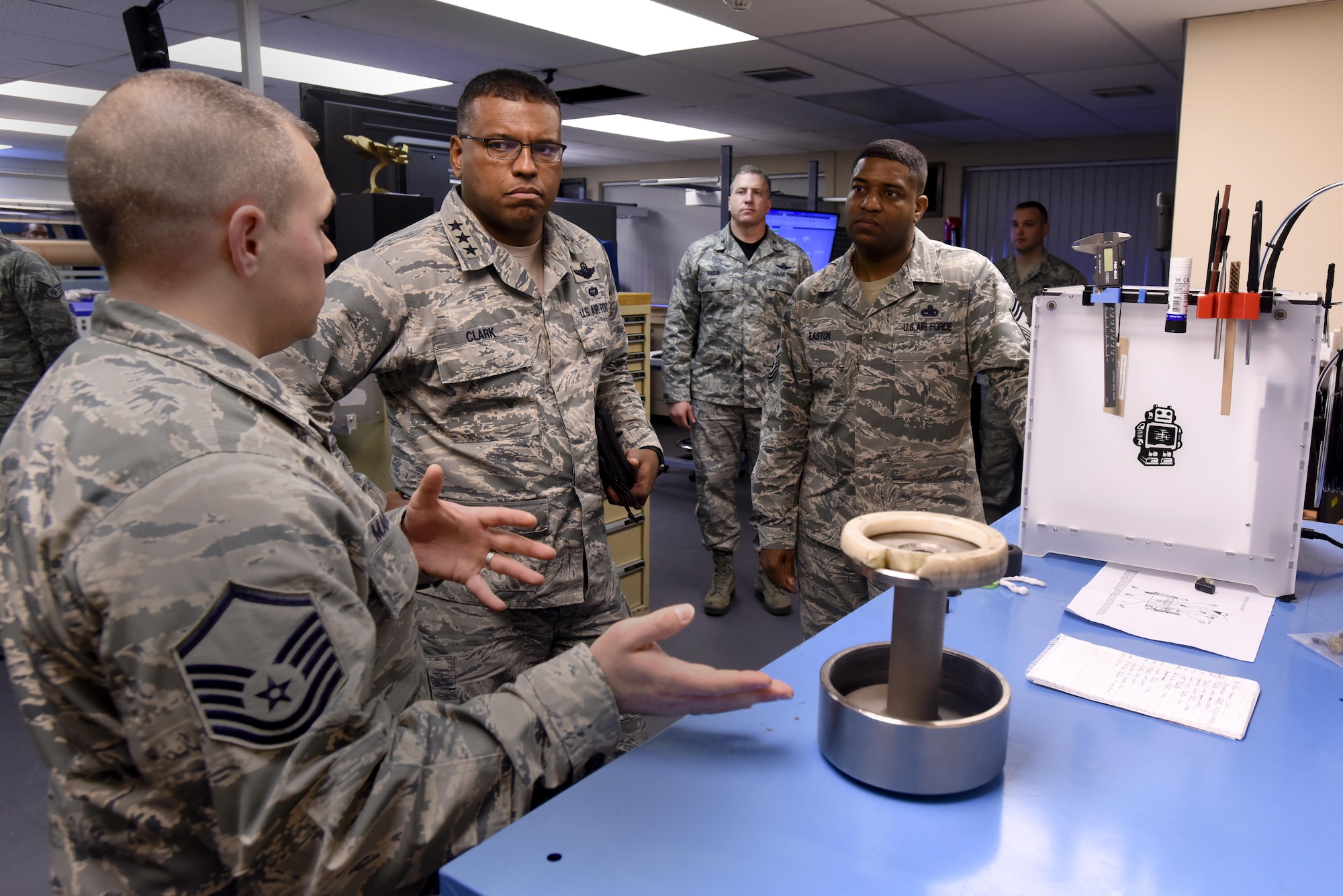 U.S. Air Force Lt. Gen. Richard Clark, 3rd Air Force commander, and Chief Master Sgt. Phillip Easton, 3rd Air Force command chief, learn about the capabilities of the 48th Maintenance Group’s 3D printer at Royal Air Force Lakenheath, England, Jan. 6. The 48th MXG has the ability to print spare parts to save the Liberty Wing time and money. (U.S. Air Force photo/Airman 1st Class Eli Chevalier)
