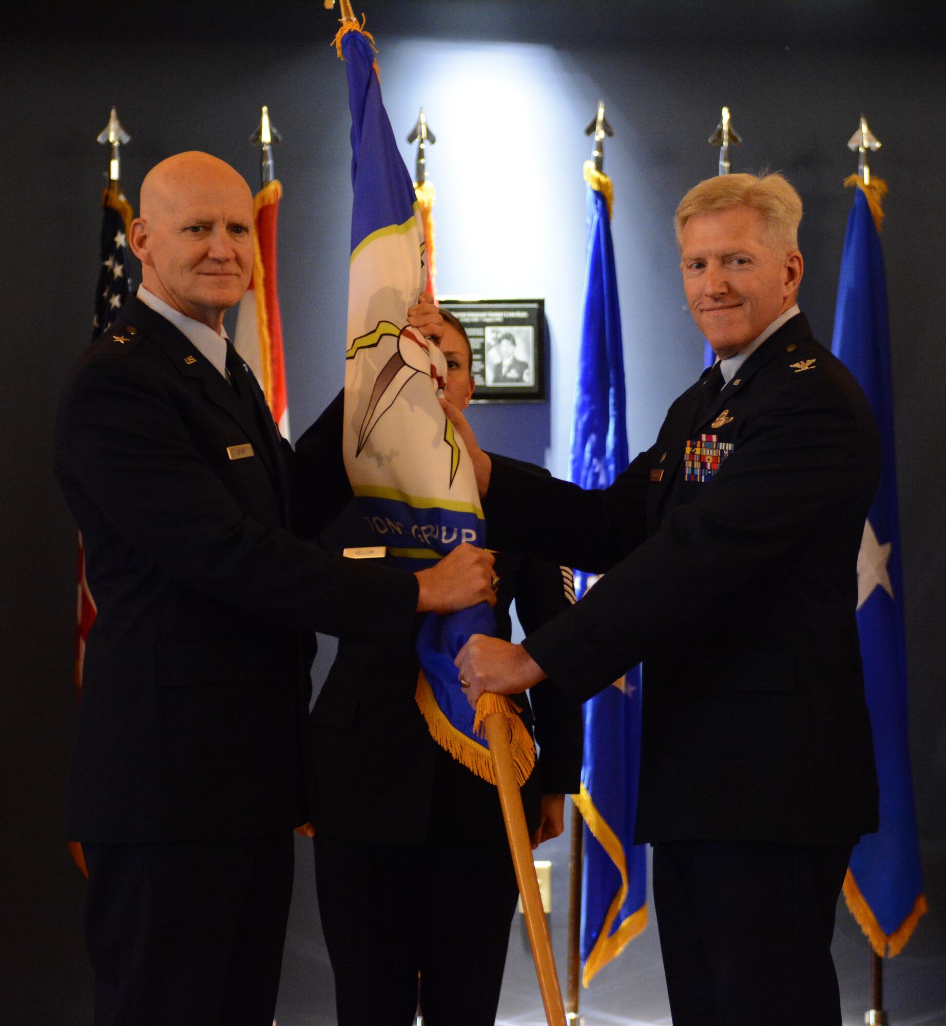 Col. Brian K. Johnson, former 101st Air and Space Operations Group commander, passes the ceremonial flag to Brig. Gen. Jim Eifert, Florida Air National Guard commander, during the change of command ceremony at Tyndall Air Force Base, Florida Jan. 5. The passing of the flag symbolizes Johnson's passing of command.