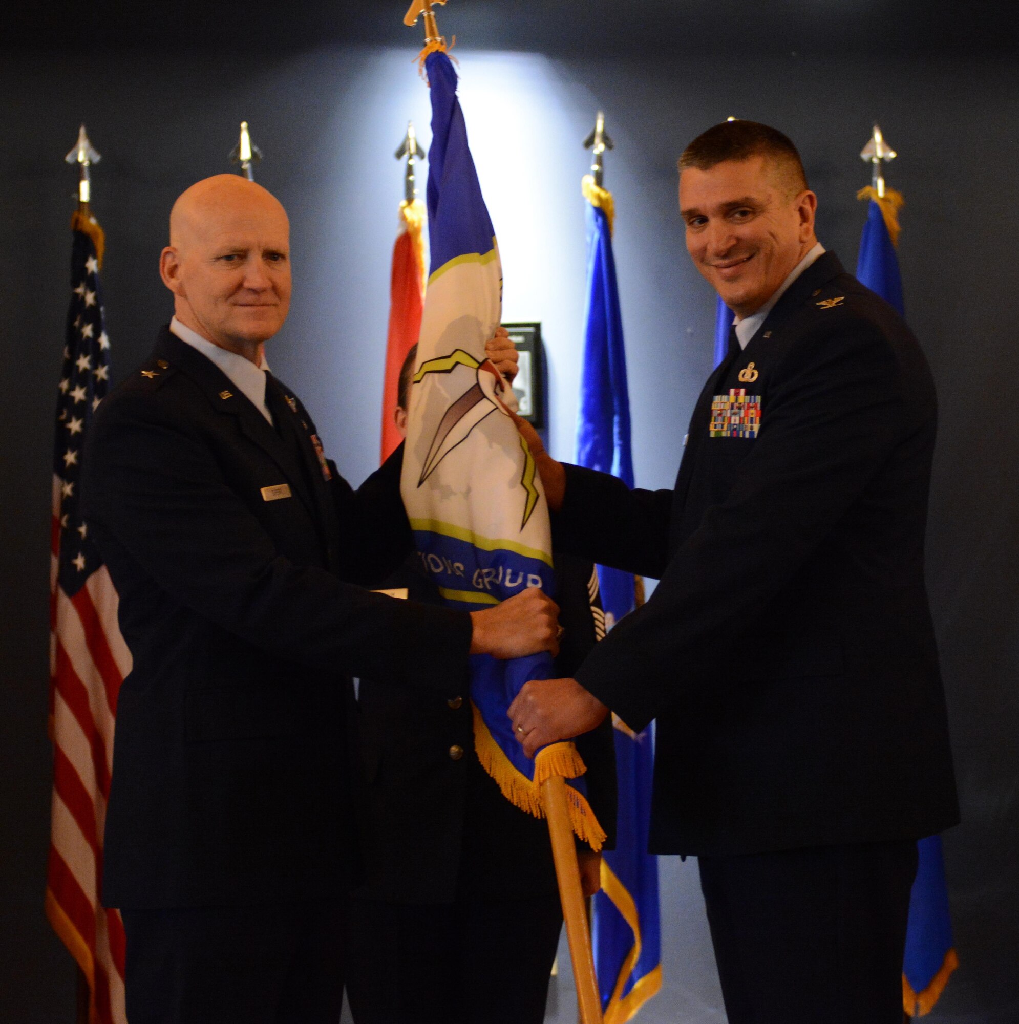 Col. Michael A Valle, 601st Air Operations Center Combat Operations Division chief, takes the ceremonial flag from Brig. Gen. Jim Eifert, Florida Air National Guard commander, during the 101st Air and Space Operations Group change of command ceremony on Tyndall Air Force Base, Florida Jan. 5. The passing of the flag symbolizes Valle's acceptance of command of the 101st AOG.