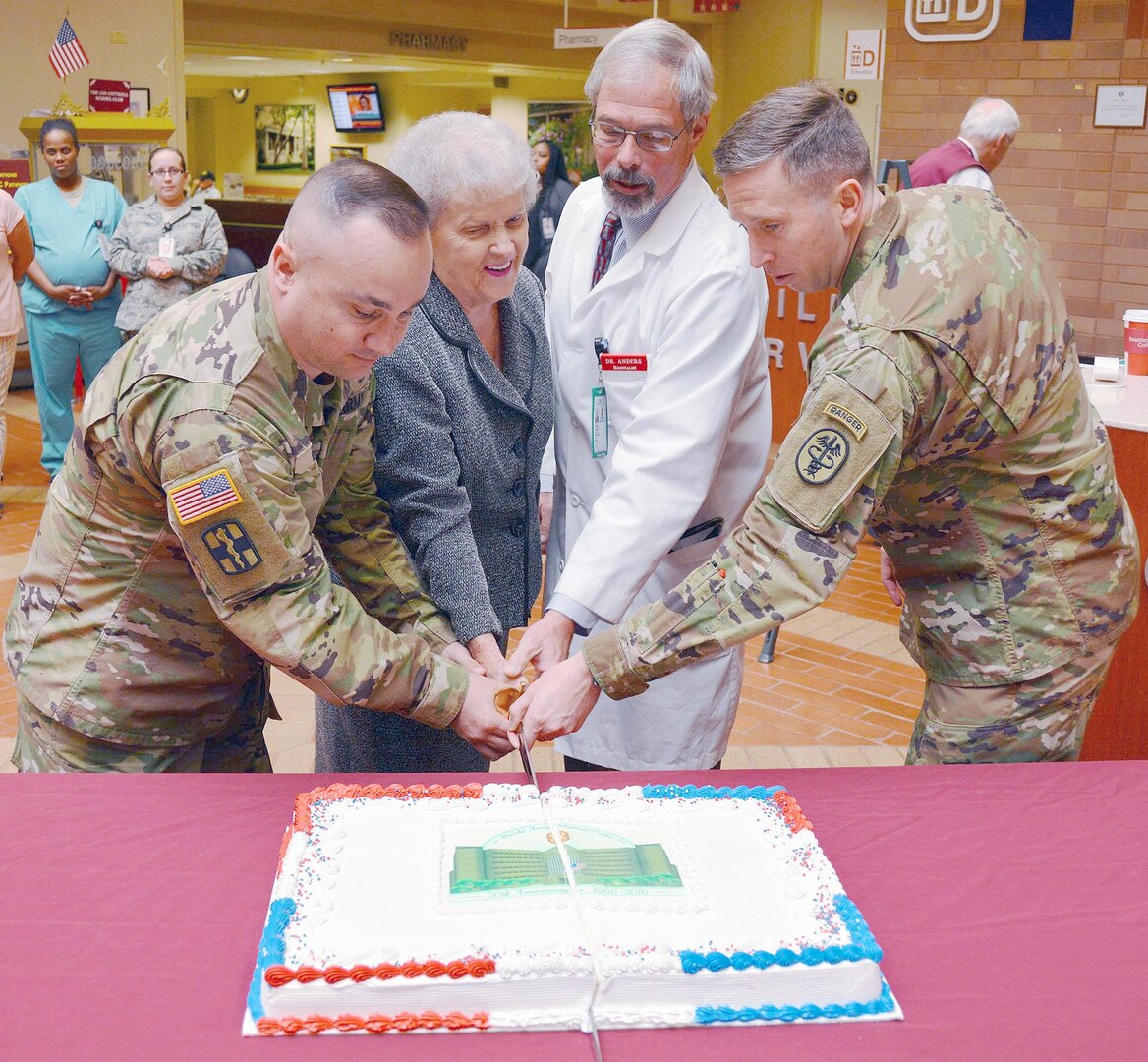 (From left) Master Sgt. John Beall, Carolyn Putnam, Dr. Gregg Anders and Brooke Army Medical Center deputy commanding officer Col. Mark Swofford cut the cake to celebrate the 20th anniversary of the “New BAMC” building April 13 in the San Antonio Military Medical Center Medical Mall. Putnam has worked at Brooke Army Medical Center for more than 55 years. Anders was the chief of chief of pulmonary and critical care 20 years ago when patients were moved from main post to the new facility.