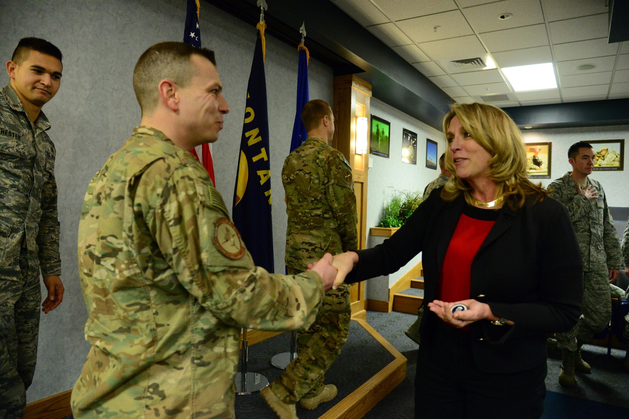 Secretary of the Air Force Honorable Deborah Lee James coins Master Sgt. Cory La Salle, 741st Missile Security Forces Squadron convoy response force section chief, at Malmstrom Air Force Base, Mont., Jan. 5, 2017. During her visit, James discussed improvements in morale, innovation and modernization with enlisted Airmen from all squadrons and ranks to gain a better understanding on what areas and processes still need to be evaluated for positive change or more effective mission accomplishment from a tactical perspective. (U.S. Air Force photo/Airman 1st Class Magen M. Reeves)