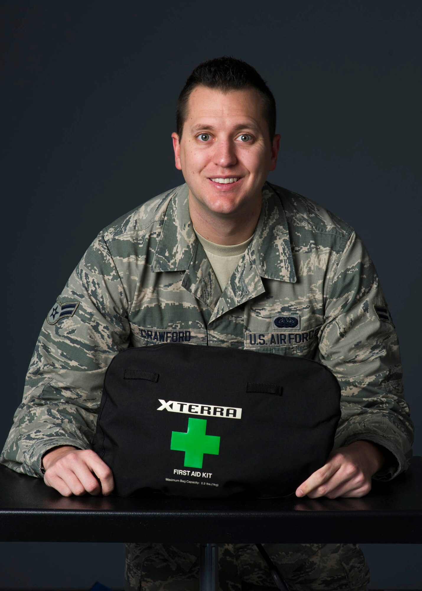 Airman 1st Class Richard Crawford, 60th Communications Squadron cyber security journeyman, poses for a photo with his first aid kit at Travis Air Force Base, Calif., Jan. 5, 2017. Crawford used the kit to care for an injured motorcyclist while traveling in Northern California. (US Air Force Photo by T.C. Perkins Jr.)