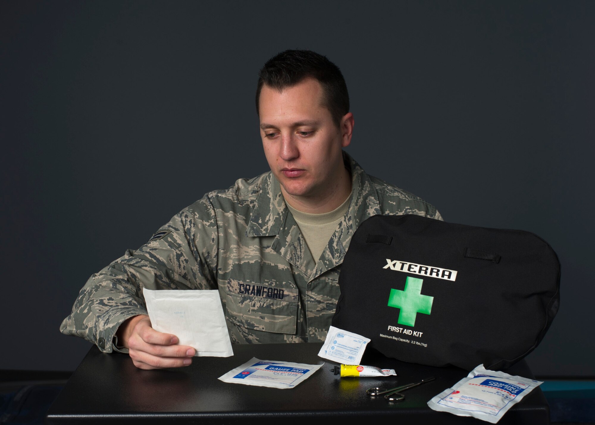 Airman 1st Class Richard Crawford, 60th Communications Squadron cyber security journeyman, looks at the contents of his first aid kit at Travis Air Force Base, Calif., Jan. 5, 2017. Crawford used the kit to care for an injured motorcyclist while traveling in Northern California. (US Air Force Photo by T.C. Perkins Jr.)