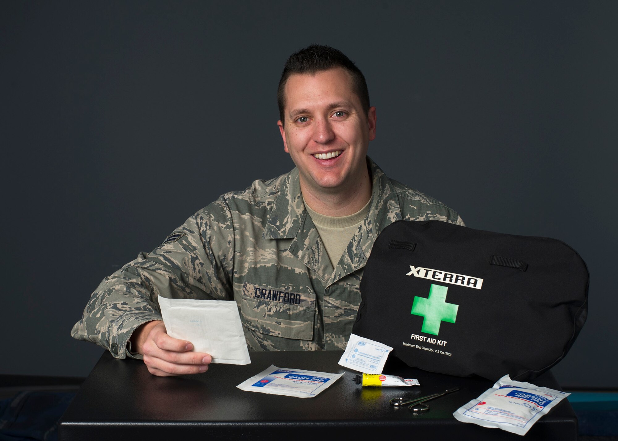 Airman 1st Class Richard Crawford, 60th Communications Squadron cyber security journeyman, poses for a photo with his first aid kit at Travis Air Force Base, Calif., Jan. 5, 2017. Crawford used the kit to care for an injured motorcyclist while traveling in Northern California. (US Air Force Photo by T.C. Perkins Jr.)