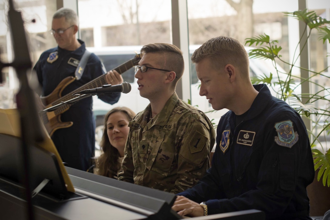 U.S. Army Specialist Tyler McGibbon, National Intrepid Center of Excellence patient, and U.S. Air Force Master Sgt. Jonathon McPherson, U.S Air Force Bann Max Impact keyboard player, perform “The Messenger” by Linkin Park at NICoE Creative Arts Café at Walter Reed National Military Medical Center in Bethesda, Md., Dec. 13, 2016. NCAC is performance platform for NICoE patients and staff to share creativity though creative arts once a month. NCAC began as a collaboration between the U.S. Air Force Band and NICoE music therapy program October 2016. (U.S. Air Force photo by Airman 1st Class Rustie Kramer)