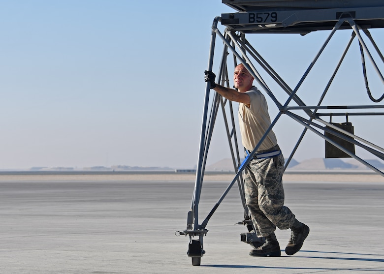 U.S. Air Force Staff Sgt. James Swann, a crew chief with the 379th Expeditionary Aircraft Maintenance Squadron, 746th Expeditionary Aircraft Maintenance Unit, moves a platform at Al Udeid Air Base, Qatar, Dec. 30, 2016. Swann was conducting inspections on the wing flaps of a C-130 Hercules, and used the platform to reach the wings of the aircraft. (U.S. Air Force photo by Senior Airman Miles Wilson)
