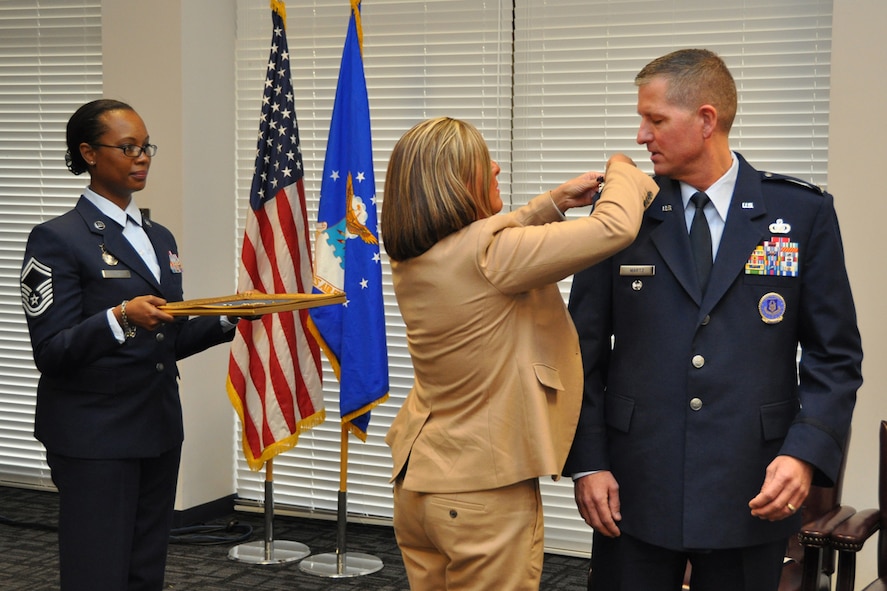 Col. Timothy H. Martz, Air Force Reserve Command Recruiting Service vice commander, and former 94th Security Forces Squadron commander, is pinned-on by his wife Heidi during his promotion ceremony Jan. 4, 2017 at Verhulst Hall, Dobbins Air Reserve Base, Georgia. Senior Master Sgt. Engle Coulter, 94th SFS operations superintendent, served a proffer. (U.S. Air Force photo/James Branch)