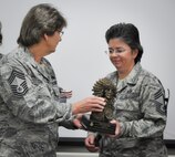 Chief Master Sgt. Pamela Duvall, 919th Special Operations Maintenance Group, presents a Native American chief bust to newly promoted Chief Master Sgt. Laurie Kent, 919th Special Operations Force Support Squadron, at her Chief Induction ceremony Jan. 7 at Duke Field, Fla.  Kent was promoted to chief via the Stripes for Exceptional Performers II program in August.  (U.S. Air Force photo/Lt. Col. James Wilson)