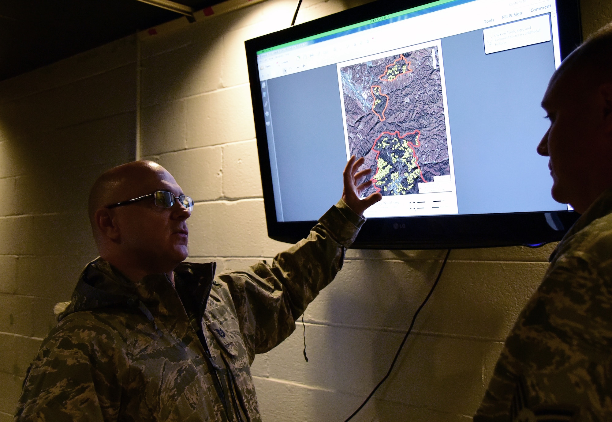 Tech. Sgt. Daron, a member of the 236th Intelligence Support, shows an airmen a map of the fires in east Tennessee on Jan. 7, 2017 a Berry Field Air National Guard Base in Nashville, Tenn. The 236th IS provided valuable imagery and mapping support to the Tennessee Emergency Management Agency and other civilian agencies fighting the fires. 