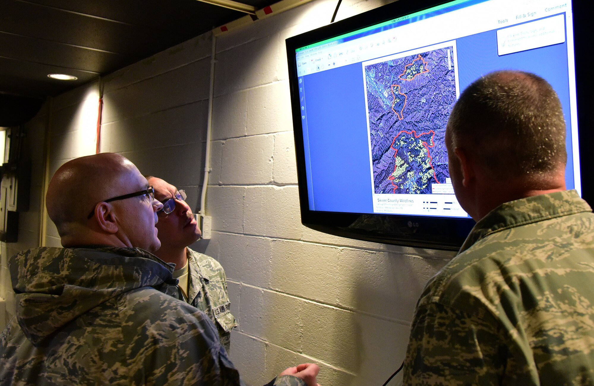 Tech. Sgt. Daron, a member of the 236th Intelligence Support, shows 2 airmen a map of the fires in east Tennessee on Jan. 7, 2017 a Berry Field Air National Guard Base in Nashville, Tenn. The 236th IS provided valuable imagery and mapping support to the Tennessee Emergency Management Agency and other civilian agencies fighting the fires. 