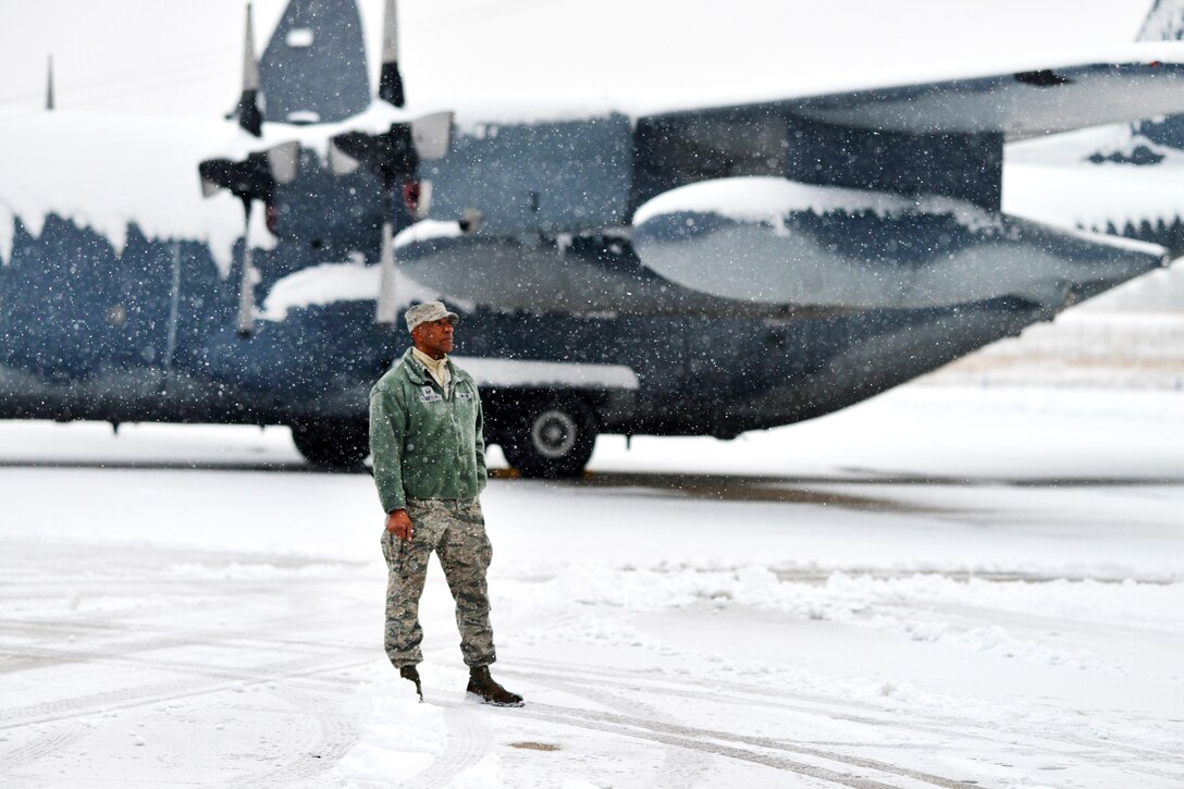 A New York Air National Guardsman observes as maintainers de-ice HC-130 Hercules aircraft and plow the runway at Francis S. Gabreski Air National Guard Base in Westhampton Beach, N.Y., during a sudden major snowstorm, Jan. 6, 2017. Air National Guard photo by Staff Sgt. Christopher S. Muncy