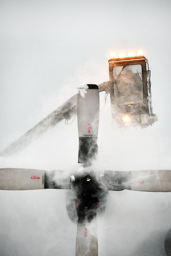 A New York Air National Guardsman de-ices the propeller on an HC-130 Hercules aircraft during a sudden major snowstorm at Francis S. Gabreski Air National Guard Base in Westhampton Beach, N.Y., Jan. 6, 2017. Air National Guard photo by Staff Sgt. Christopher S. Muncy